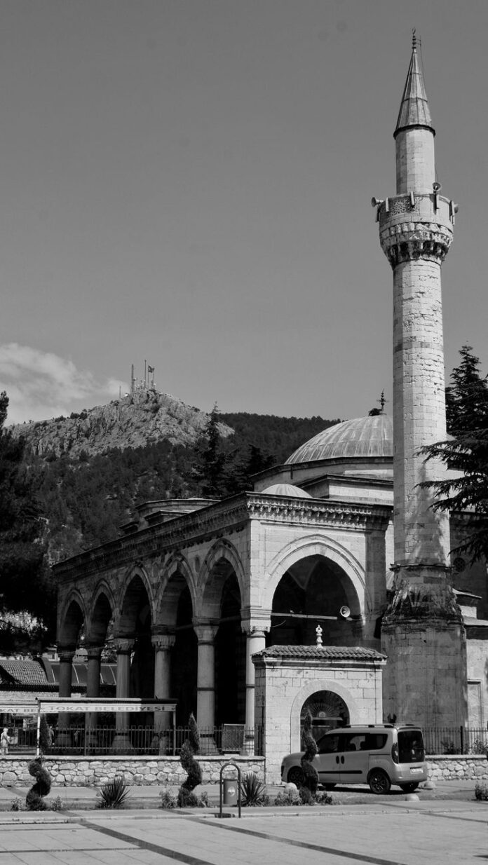 parked car beside a mosque and minaret
