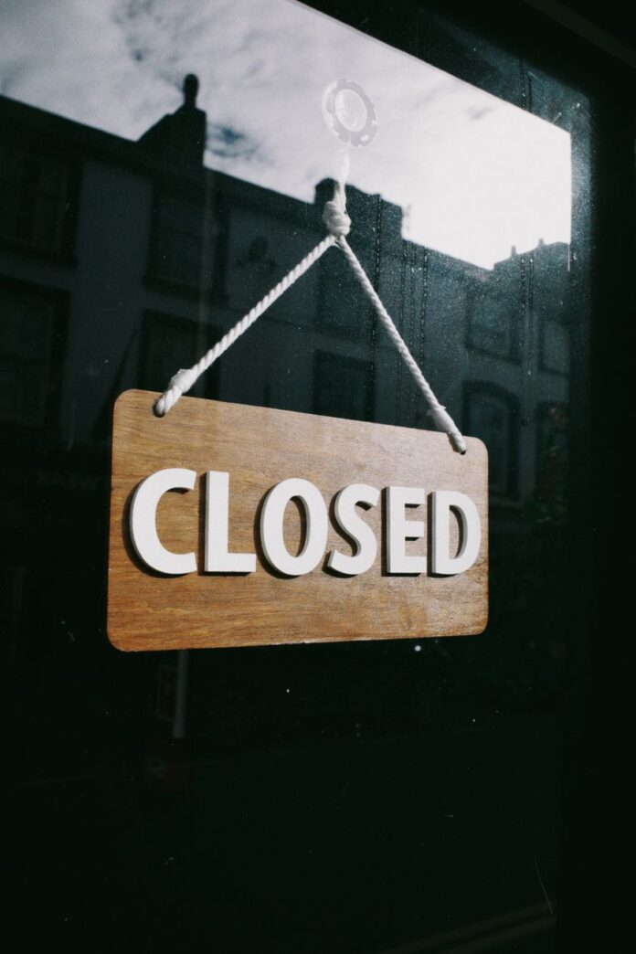 closed sign hanging on glass door