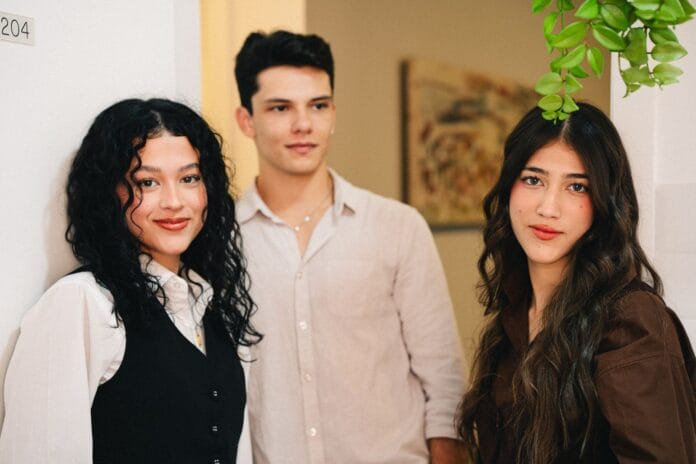 pexels-photo-27868431 three people standing in front of a plant