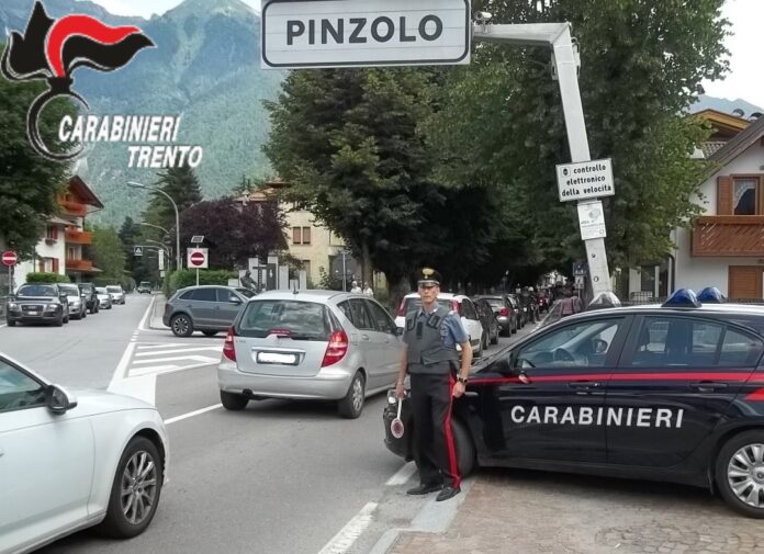 Carabiniere accanto a un’auto di servizio nel centro di Pinzolo