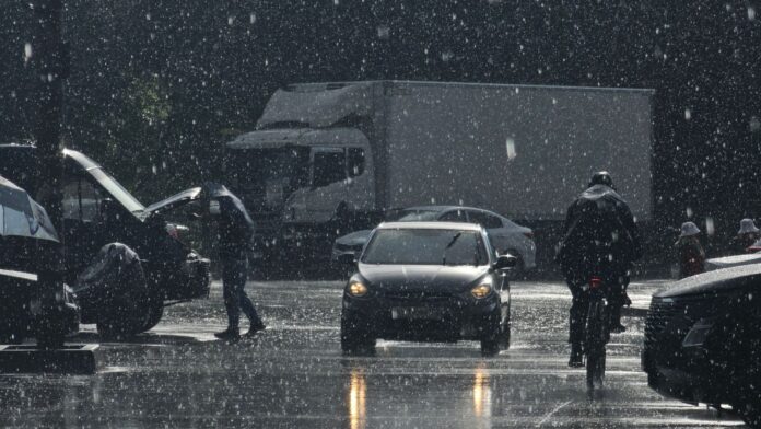 view of cars and pedestrians on the street in rain