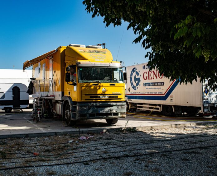 yellow truck parked outdoors in sunny setting