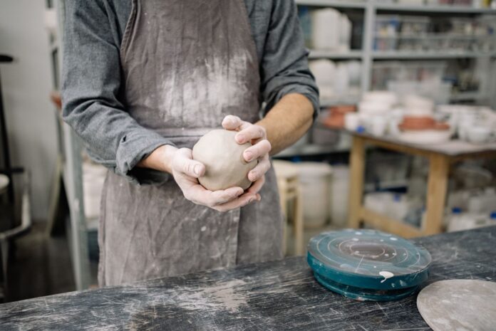 man holding a ball of clay