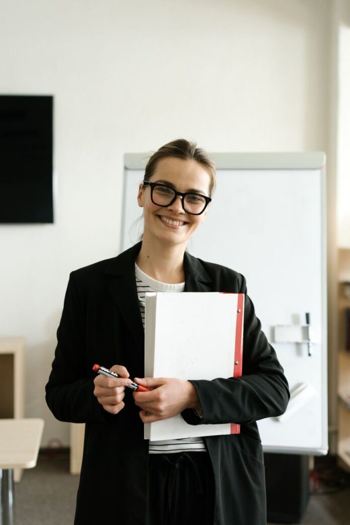 a happy woman in a black blazer and eyeglasses