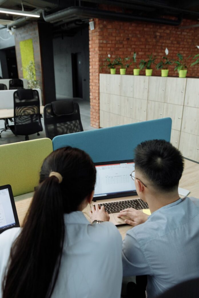 a man and a woman using a laptop